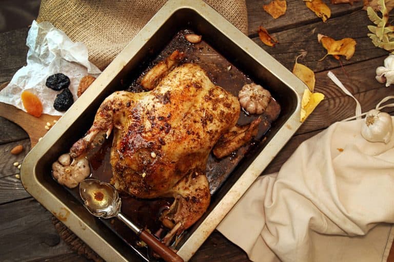 Roasted chicken with sauce on roasting pan placed on table, Does A Roasting Pan Need A Rack?