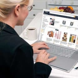 Woman in kitchen checking over her laptop browsing where to buy food containers online, Where To Buy Food Containers