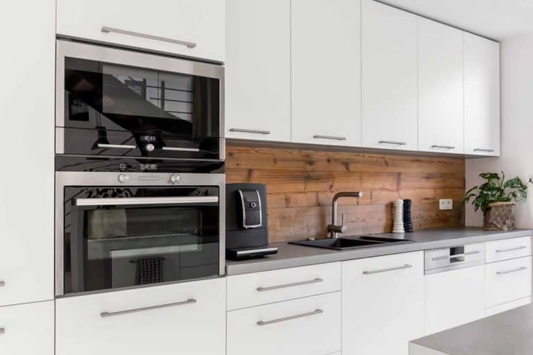 Balanced kitchen with double oven, white cabinets, grey countertop and natural accents, How Much Does a Double Oven Cost?