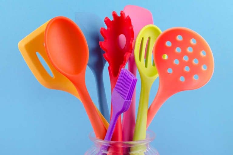 Bright multi colored silicone kitchen utensils on blue background, What Is Better: Nylon Or Silicone Utensils?