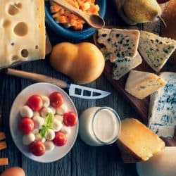 Cheese board with many varied cheeses and dairy products on a table featuring cheese knife, Why is There A Hole in a Cheese Knife?