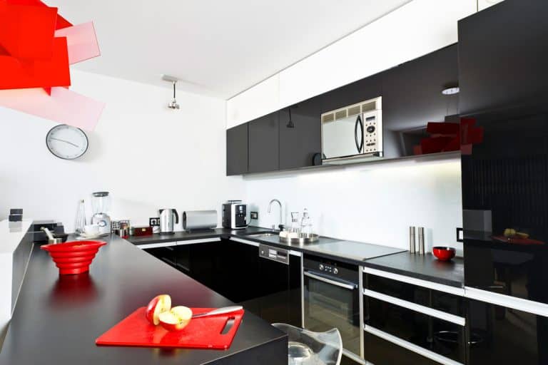 A modern kitchen with a black-white-red combination of colors, How Far Should Oven Stick Out from Cabinets?