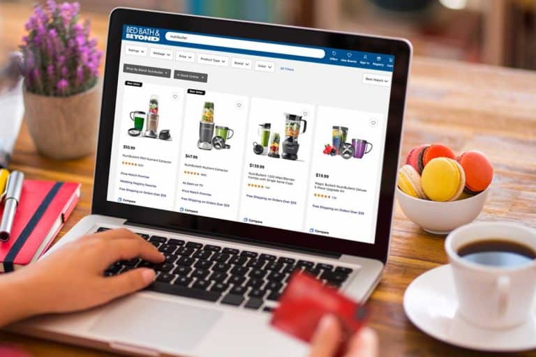 Person shopping online using a laptop holding a credit card, Where To Buy The NutriBullet [Top 25 Online Stores]