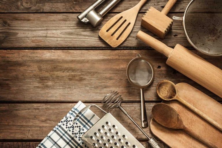 Rural kitchen utensils on vintage planked wood table from above- a perfect gift for cooking lovers, 15+ Kitchen Utensil Gift Sets For Cooking Lovers