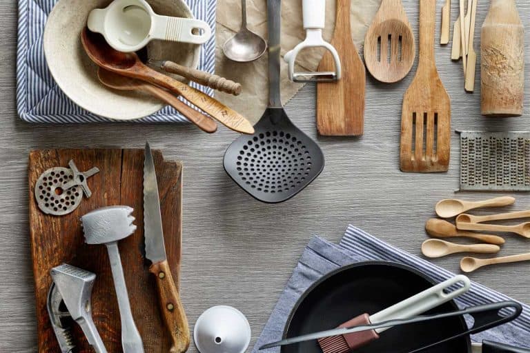 various kitchen utensils on wooden table, 33 Kitchen Gift Ideas For Moms Who Love To Cook