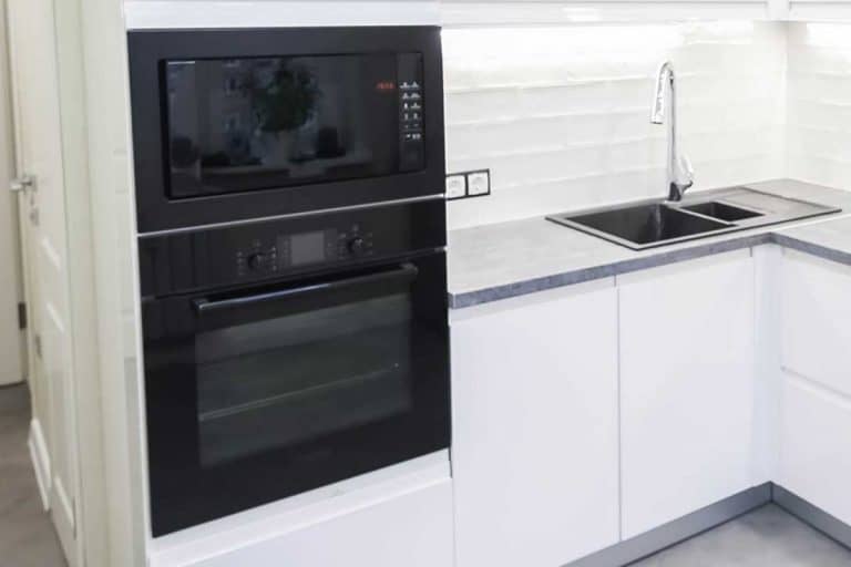 Interior of a modern compact white kitchen with gas stove and wall oven, What is the Best Brand For Wall Ovens? [7 brands reviewed]