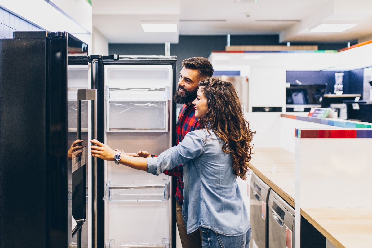 Satisfied customers choosing fridges in appliances store