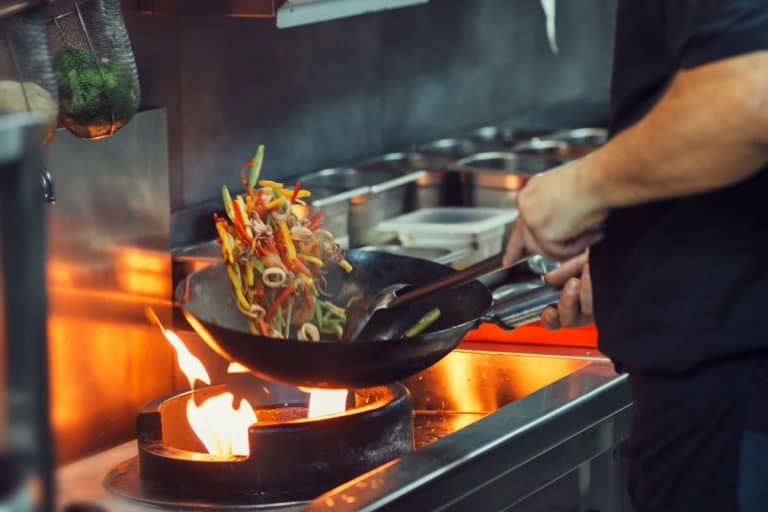 A chef cooking a special dish using a wok, How Much Does A Wok Cost on Average?