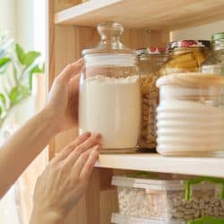 A glass jar with flour inside it properly arranged on a divider, What Is The Best Container To Store Flour? [7 Suggestions]