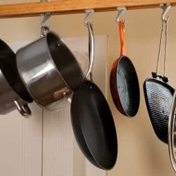 Modern kitchen with a rack of hanging pots and pans, Where Should You Store Heavy Pots? [8 Options Explored]