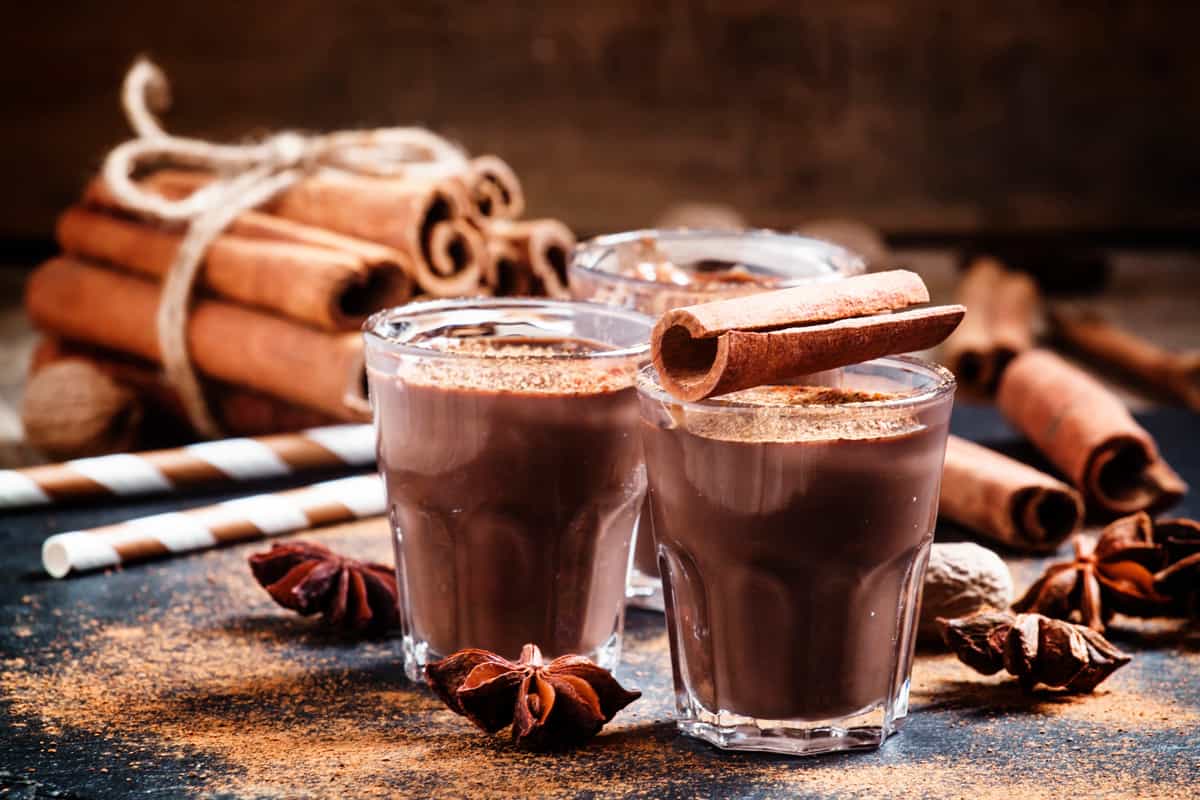 Two cups of hot chocolate drink with cinnamon rolls on the side, How to Make Large Amounts of Hot Chocolate