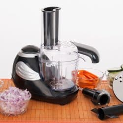 A food processor placed on a chopping board with chopped onions, bell peppers, and carrots on the side, Can You Dice Vegetables In A Food Processor?