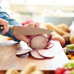 Midsection image of woman cutting onion in kitchen, What Knife Is Best For Cutting Onions?