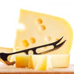 Cheese with a cheese knife on a cutting board, What Kind Of Knife Is Best For Cutting Cheese? [6 Options]