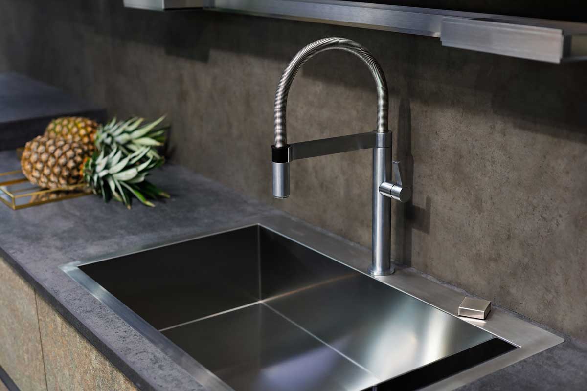 Stainless steel sink with a tap on a kitchen counter