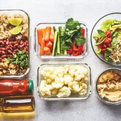 Healthy-vegan-food-in-glass-containers,-Rice,-beans,-vegetables,-hummus-and-juice,-How-To-Organize-Glass-Food-Storage-Containers-[4-Crucial-Tips]