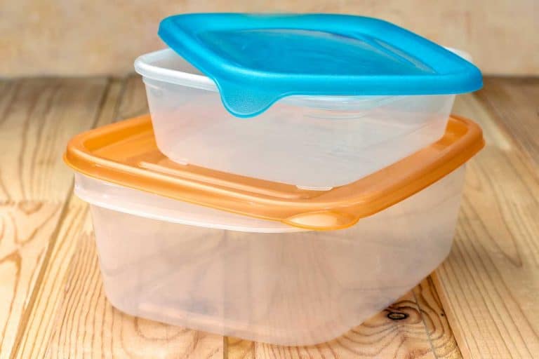 Plastic food containers on a wooden table, How To Cut a Hole In A Plastic Container (5 Effective Ways)