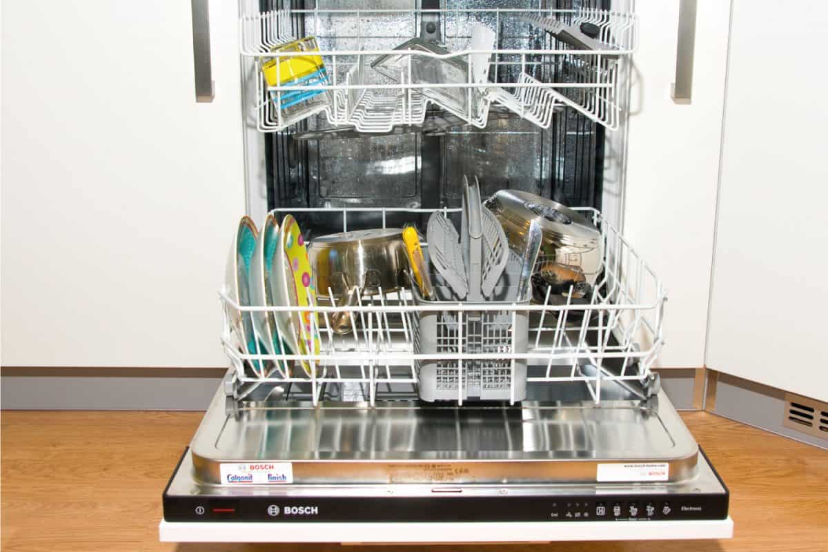 Bosch dishwasher with doors open and containing washed dishes