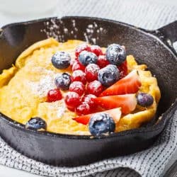 A Dutch baby pancake with berries in a cast-iron pan, How To Keep Pancakes From Sticking To The Pan