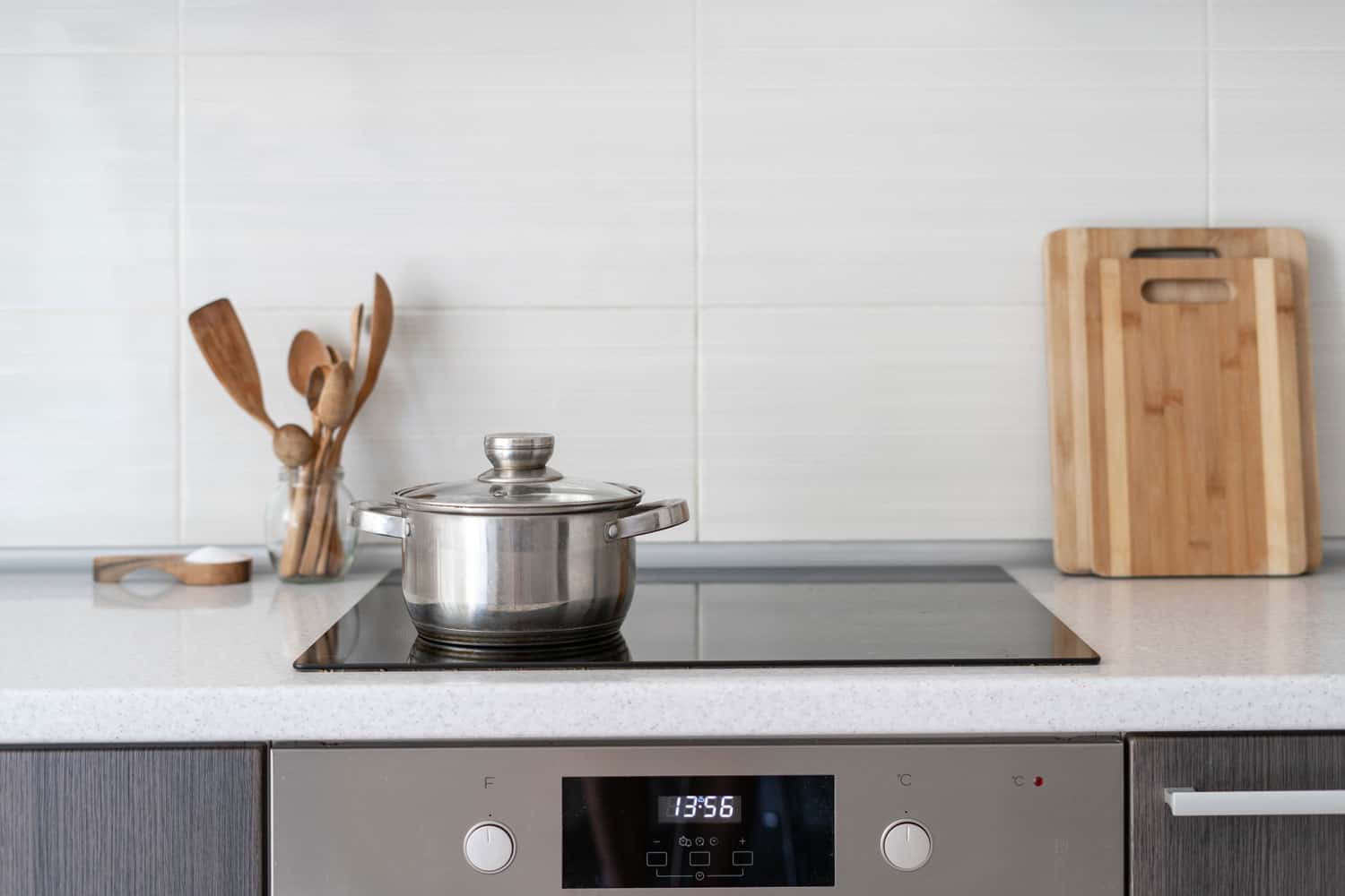 A stainless pot on an induction cooker inside a modern kitchen