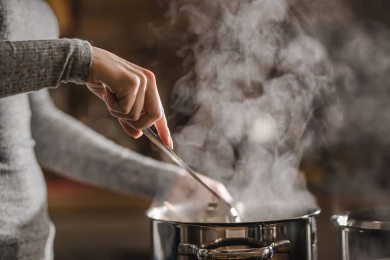 A woman holding a spatula and stirring her cooking on a pot, Is It Bad To Eat Straight Out Of The Pot?