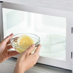 Close-up of woman putting bowl of slice lemon in microwave oven, If A Bowl Is Microwave Safe Is It Also Oven Safe?