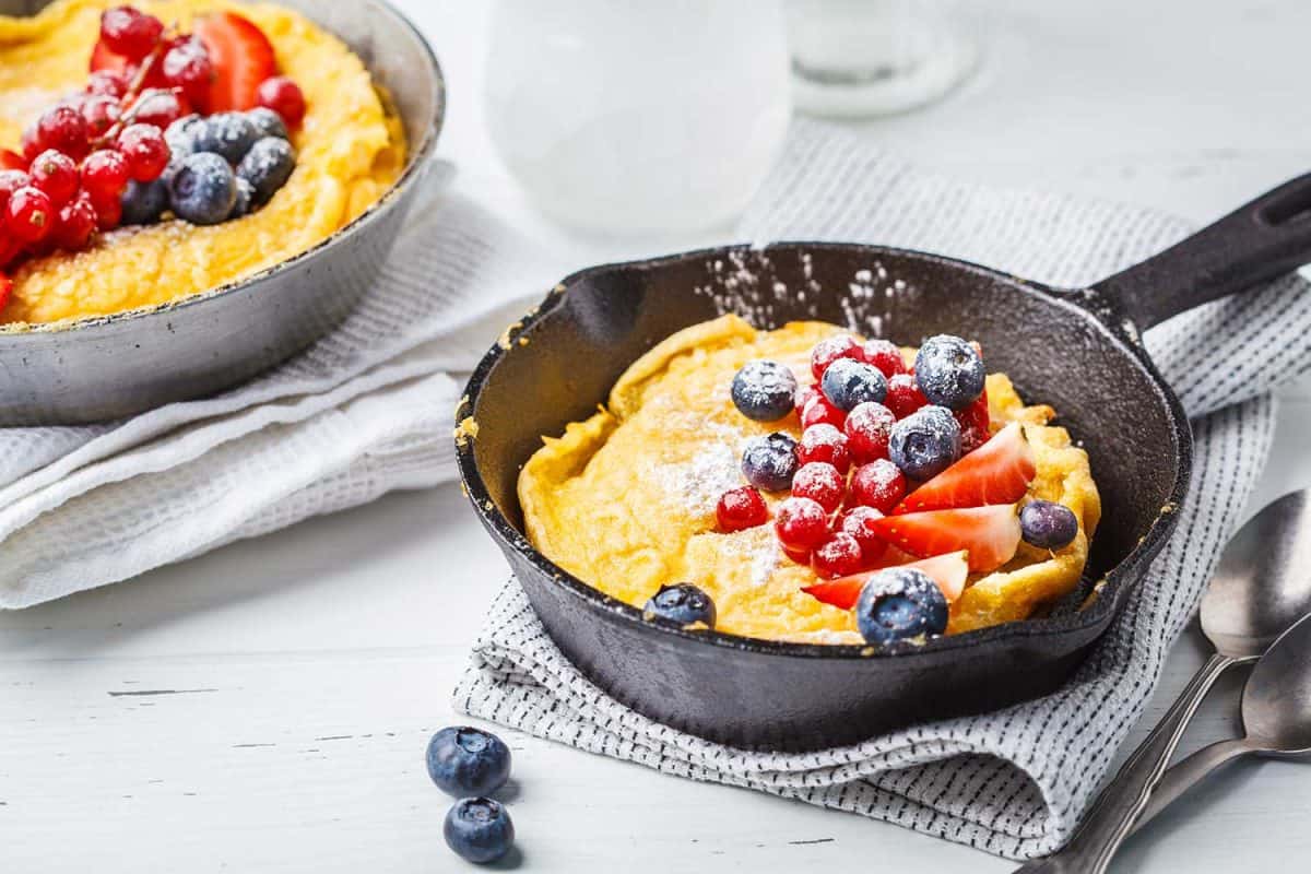 Dutch baby pancake with berries in a cast-iron pan