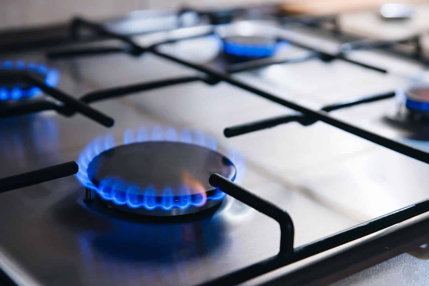 Gas kitchen stove with blue flames burning