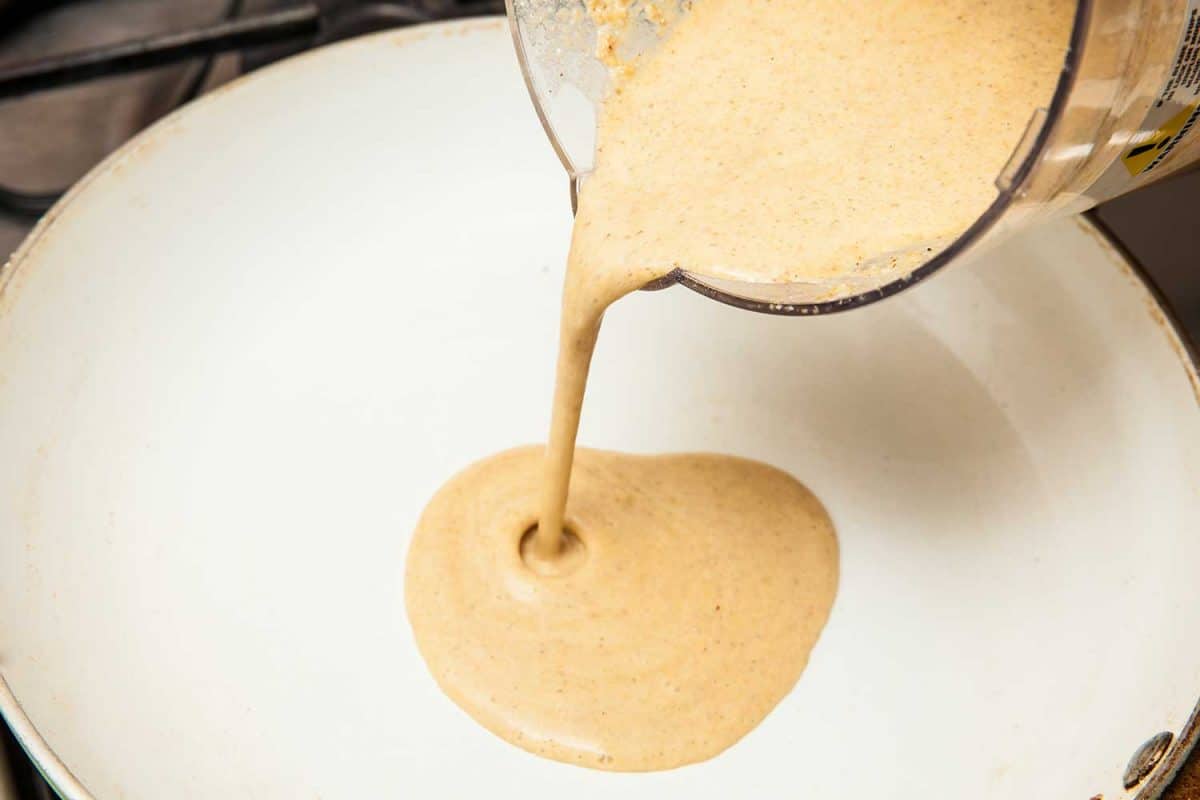 Pouring the quinoa crepes batter into a frying pan