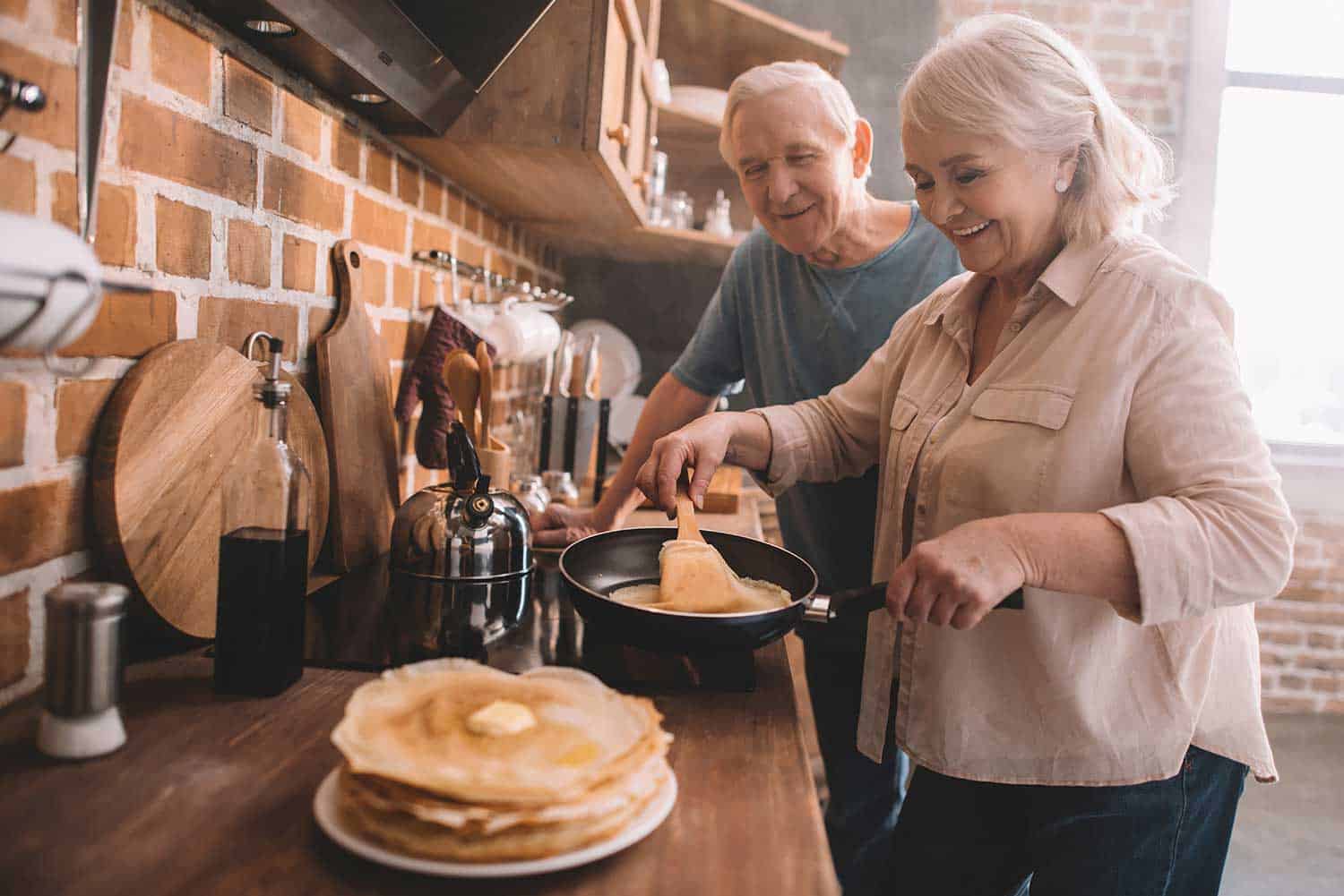 Senior couple cooking pancakes
