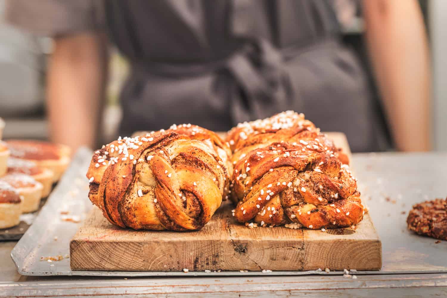 Twisted traditional Swedish cinnamon buns at a café. The sweet buns are on a wooden chopping board
