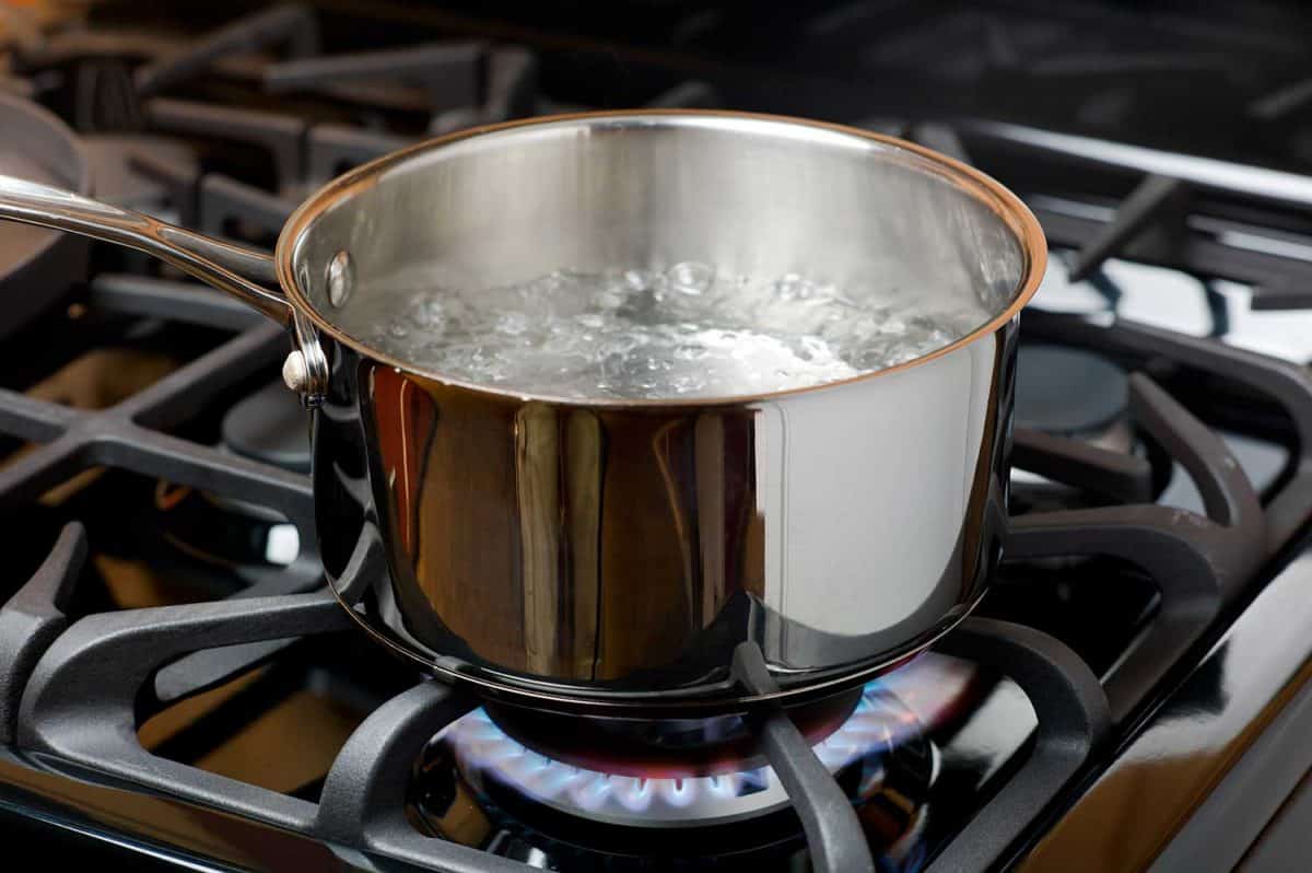Water bubbles and boils on a gas stove or range in a home kitchen