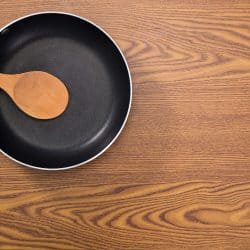 non stick frying pans on wooden background, How To Make Food Not Stick To Pan Without Oil