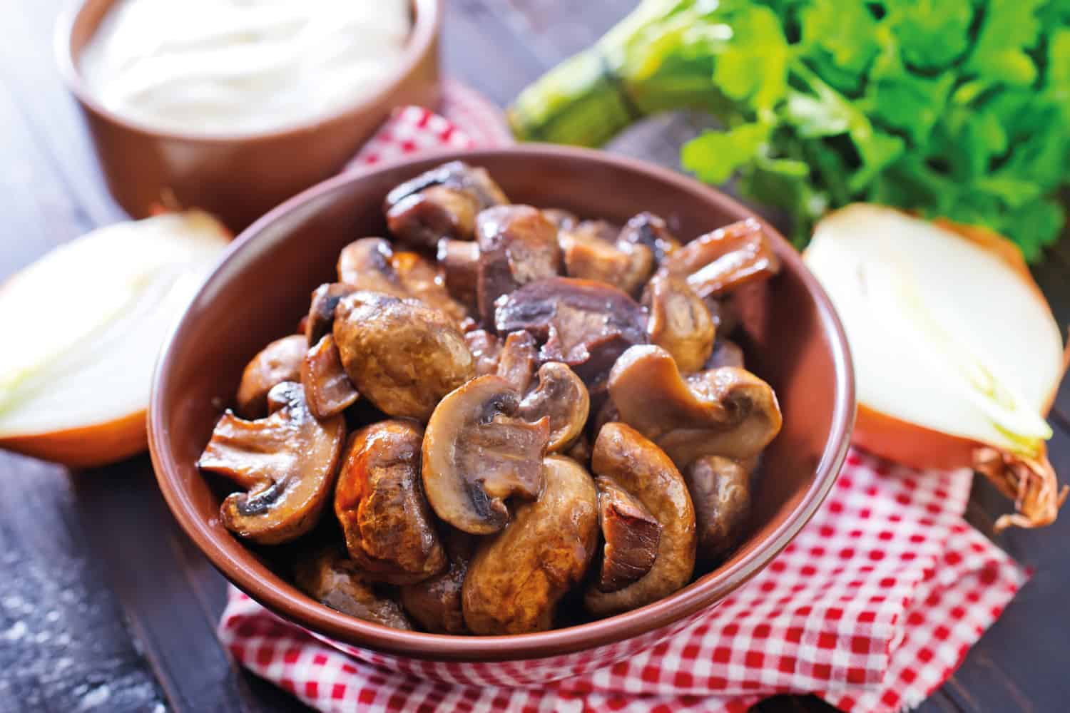 Sauteed button mushrooms on a brown bowl on top of table