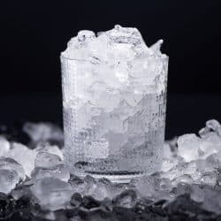 A glass filled with crushed ice inside and scattered on the sides, 5 Ways To Crush Ice Without A Blender