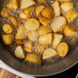 A sauce pan filled with deep fried sliced potatoes, Should You Dry Potatoes Before Frying Or Roasting?