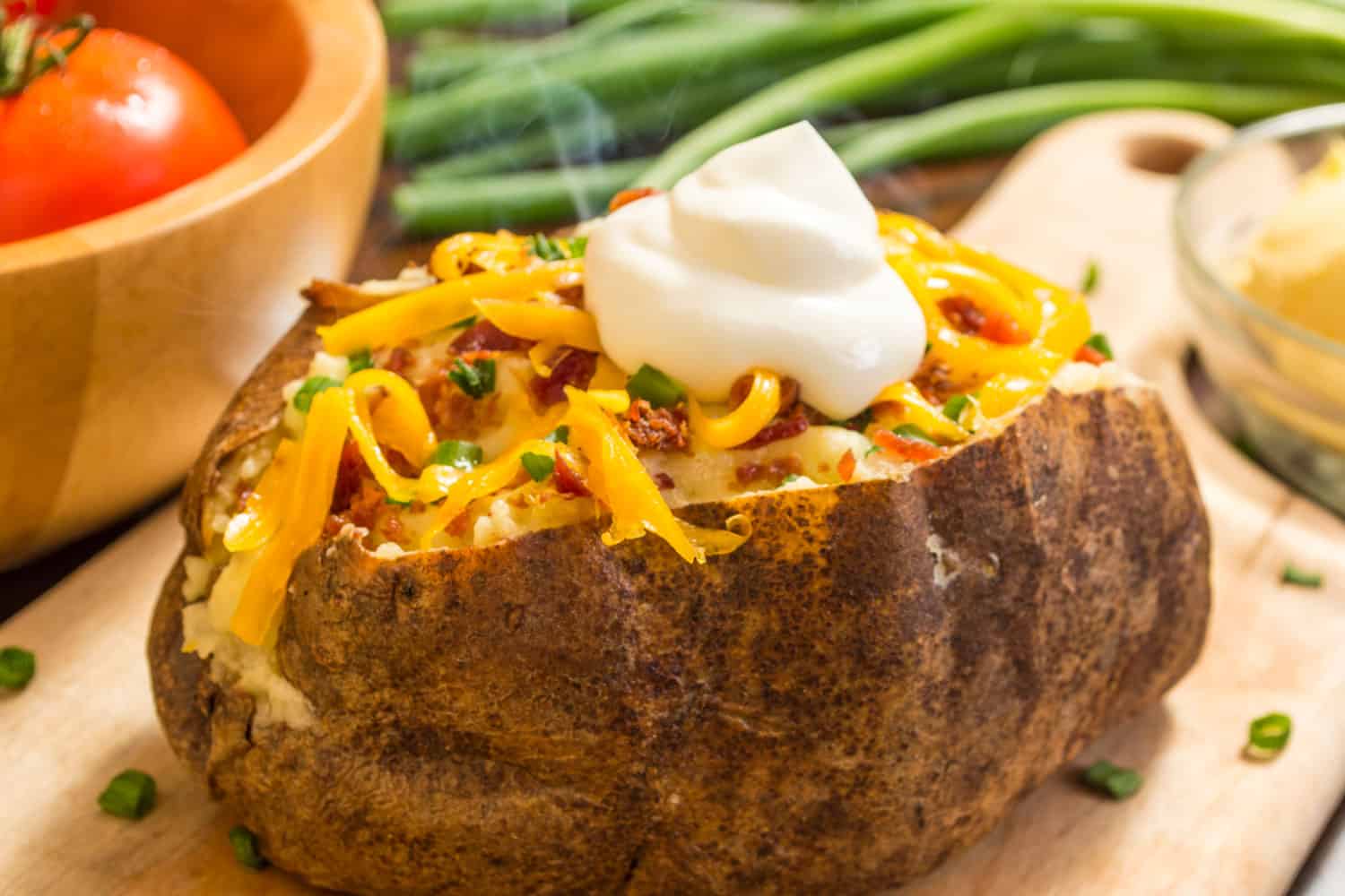 Fresh hot and smoking baked potatoes with bacon cheese and chives