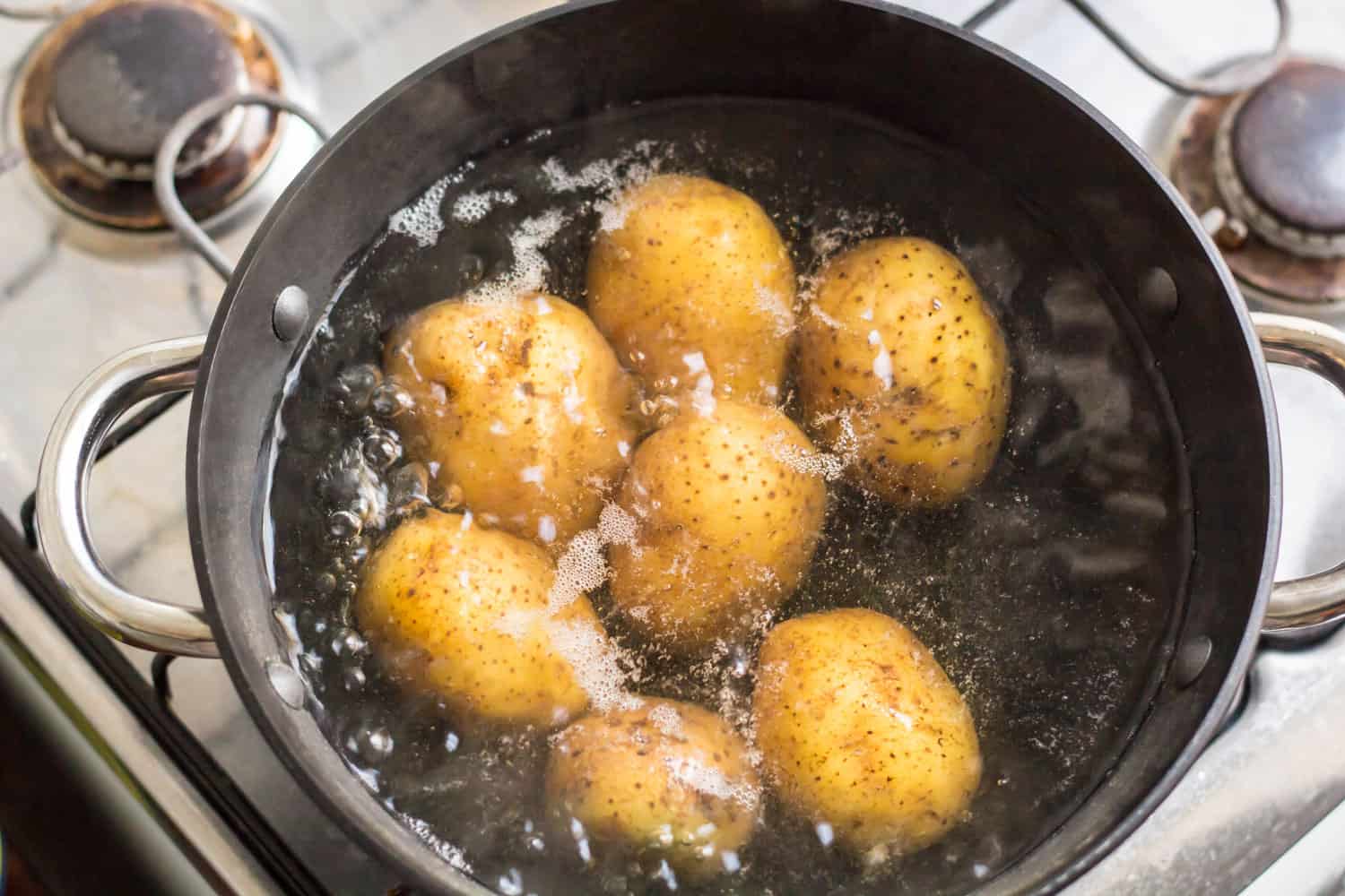 Potatoes being boiled on a saucepan under high heat