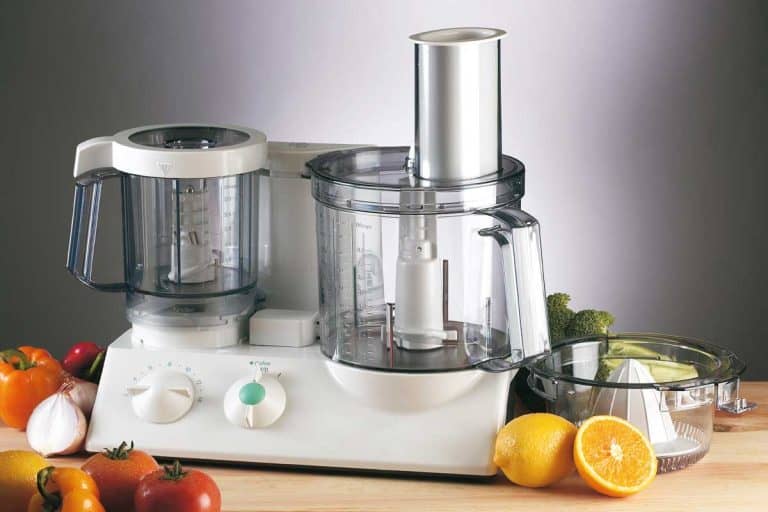 Food processor mixer with tomato, broccoli, lemon and onion on wooden table, 11 Types Of Food Processor Blades And How To Use Them