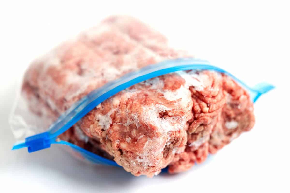 Grind meat placed inside a Ziploc bag on a white background