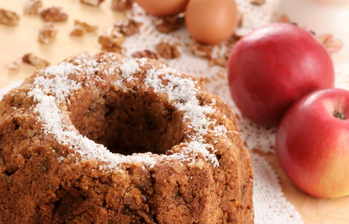 A delicious apple nut cake with some of it's main ingredients in the background. Shallow DOF, focus on the front edge of the cake