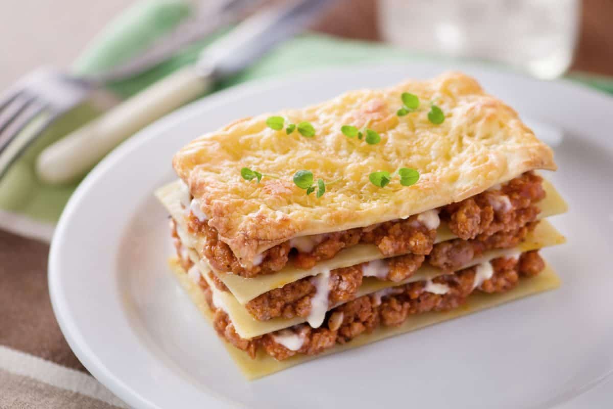 A delicious slice of lasagna on a white platter