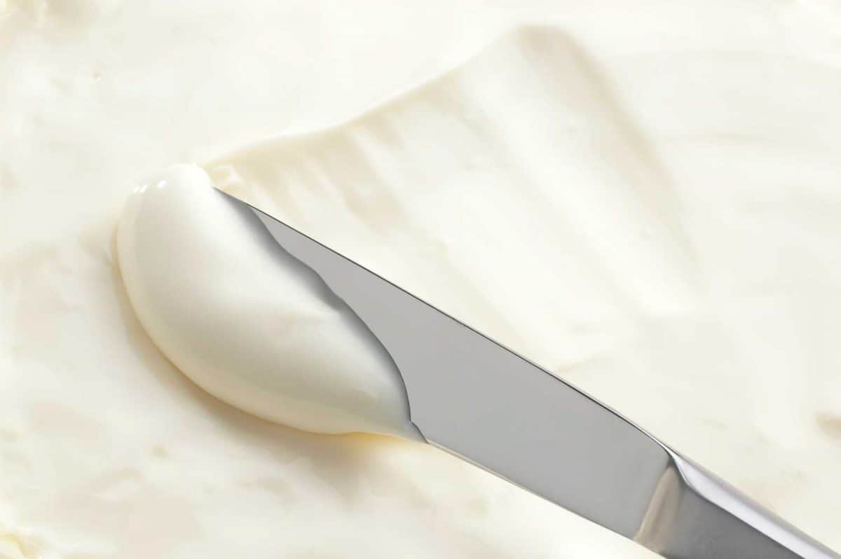 A table knife swiping into some cream cheese