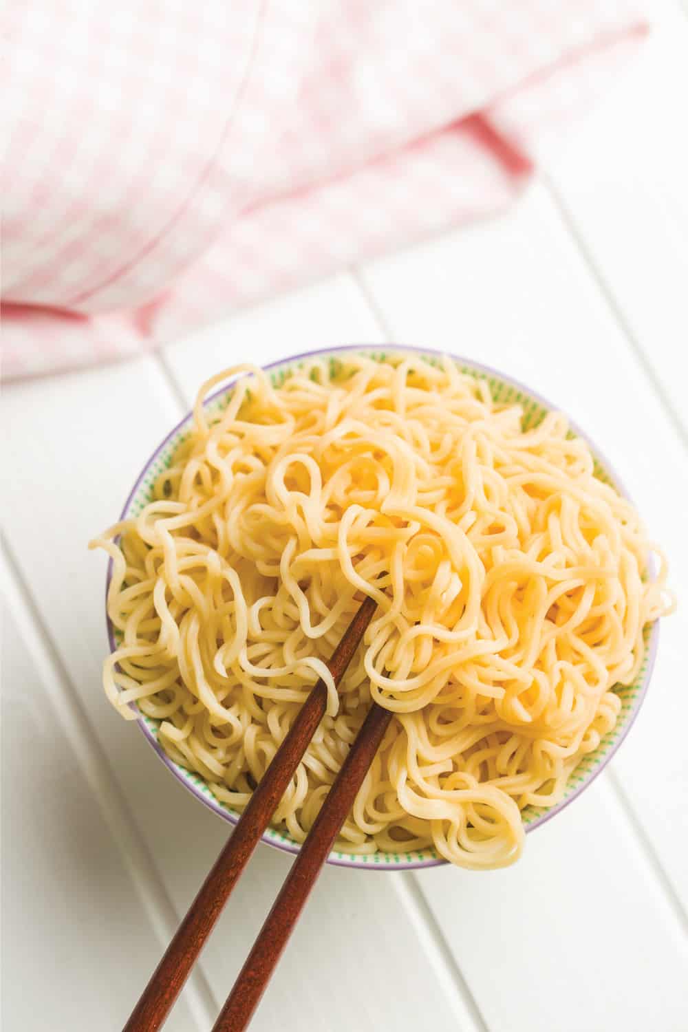 Cooked chinese instant noodles in bowl and chopsticks
