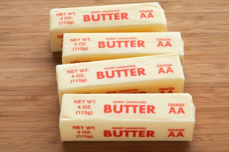 Four unwrapped unsalted butter on a wooden table, Should You Bake With Unsalted Or Salted Butter?