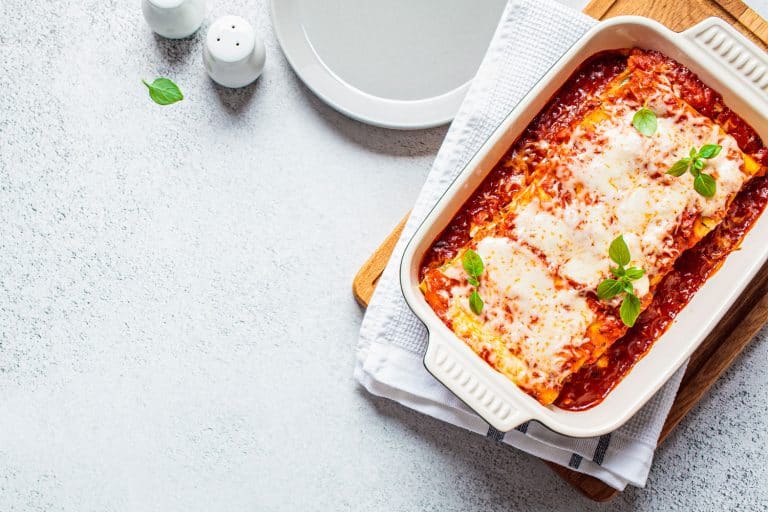 Freshly cooked lasagna placed on top of a chopping board, Can You Have Rice With Lasagna?