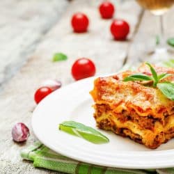 Meat lasagna on a white wood background, Can You Make Lasagna Without Cooking The Noodles?