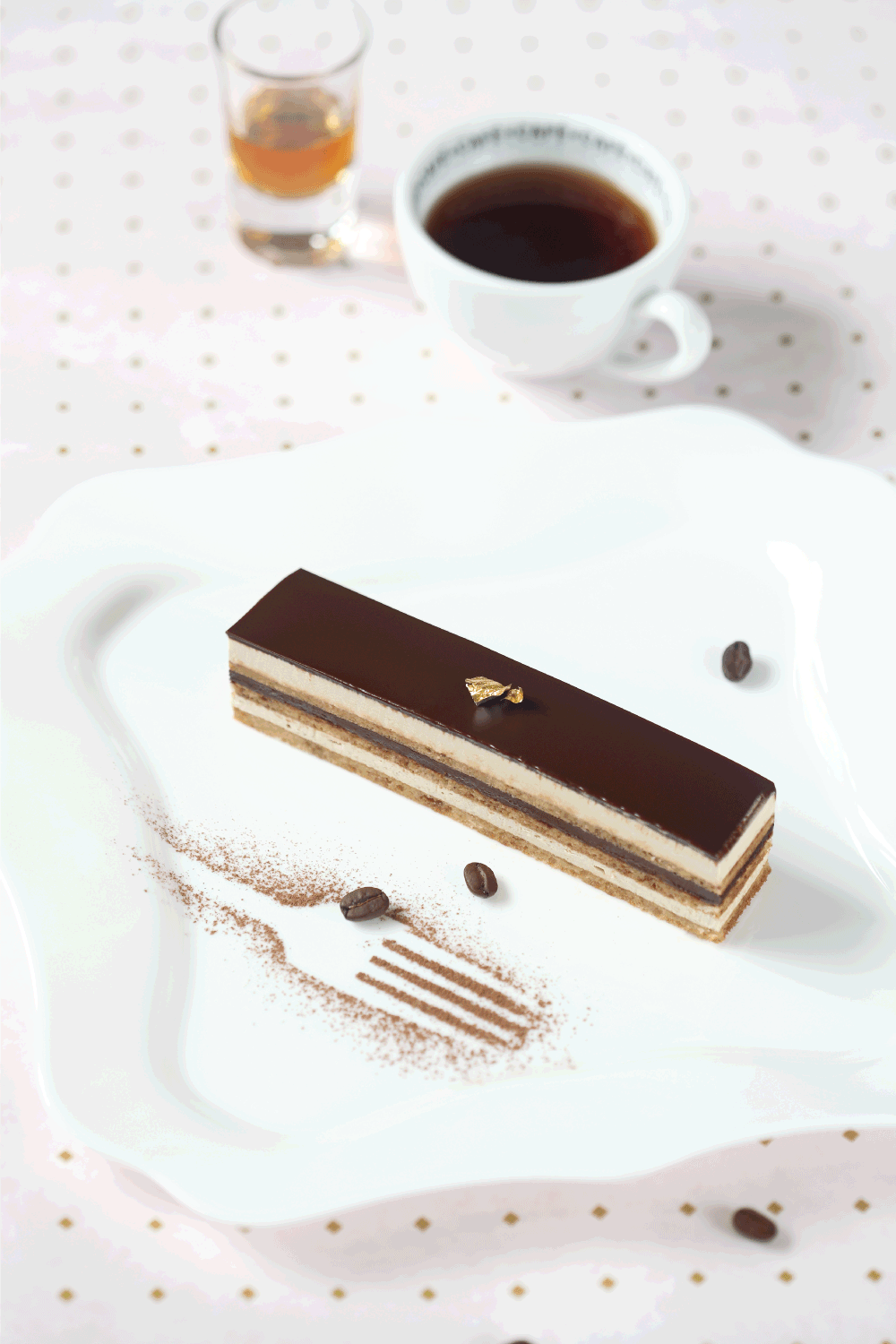 Opera Chocolate Coffee Cake on square white plate and cup of coffee
