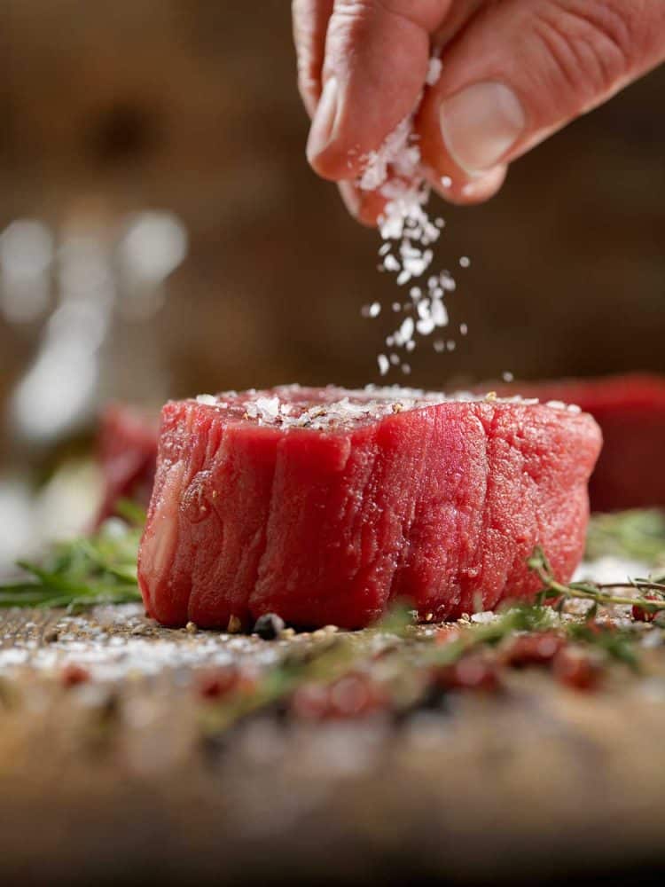 Seasoning raw fillet mignon steaks