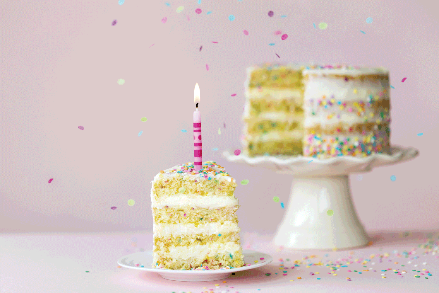 birthday layer cake with one candle and a single slice removed